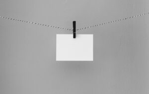white business card on a black and white string held by a black peg in the center